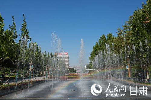兰州石化厂前广场水虹相映，绿树环绕。人民网记者 焦隆摄