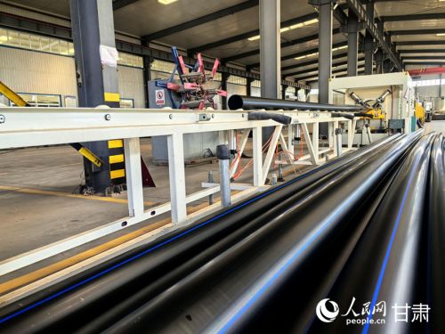 甘肃雨禾节水灌溉设备有限公司生产车间里，PE100给水管陆续下线。人民网记者 周婉婷摄