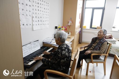 钢琴旁，王秀萍老人和老友在专注弹唱。人民网记者 焦隆摄