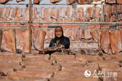 郭陇陇正在整理晾晒的腊肉。人民网记者 焦隆摄