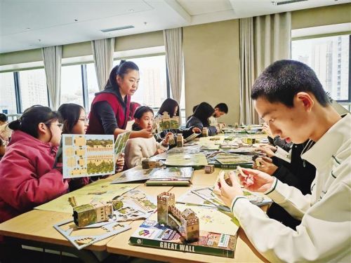青少年在老师的指导下制作长城模型